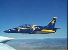 Photo shows an ACL Oshkosh award-winning L-39C aircraft after restoration. It is photographed mid-flight and is painted in the early Blue Angel A-4 color scheme.